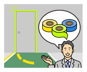 非常口に注意喚起用のテープを貼っている